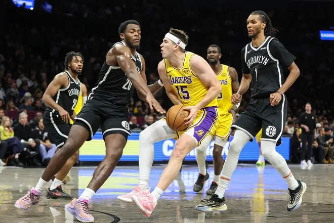 Feb 3, 2026; Brooklyn, New York, USA; Los Angeles Lakers guard Austin Reaves (15) looks to drive past Brooklyn Nets center Day'ron Sharpe (20) in the fourth quarter at Barclays Center.
