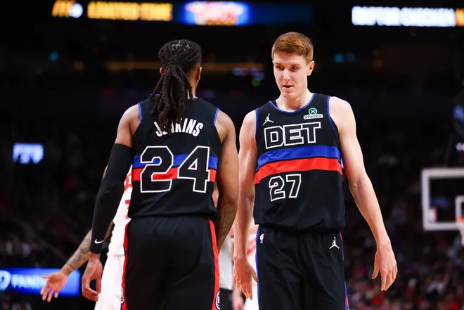 Kevin Huerter #27 of the Pistons and Daniss Jenkins #24 walk alongside each other during the second half.