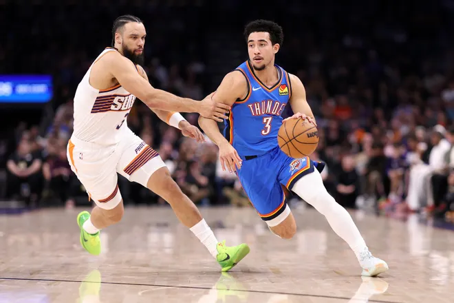 PHOENIX, ARIZONA - FEBRUARY 11: Jared McCain #3 of the Oklahoma City Thunder dribbles the ball against Dillon Brooks #3 of the Phoenix Suns during the first half at Mortgage Matchup Center on February 11, 2026 in Phoenix, Arizona. NOTE TO USER: User expressly acknowledges and agrees that, by downloading and or using this photograph, User is consenting to the terms and conditions of the Getty Images License Agreement. (Photo by Chris Coduto/Getty Images)