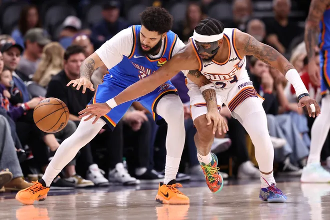 PHOENIX, ARIZONA - FEBRUARY 11: Jordan Goodwin #23 of the Phoenix Suns pressures Kenrich Williams #34 of the Oklahoma City Thunder during the second half at Mortgage Matchup Center on February 11, 2026 in Phoenix, Arizona. NOTE TO USER: User expressly acknowledges and agrees that, by downloading and or using this photograph, User is consenting to the terms and conditions of the Getty Images License Agreement. (Photo by Chris Coduto/Getty Images)