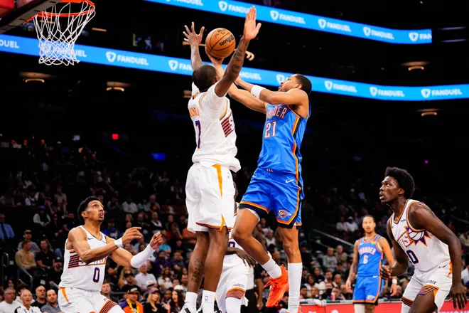 Feb 11, 2026; Phoenix, Arizona, USA; Oklahoma City Thunder guard Aaron Wiggins (21) goes for a shot against Phoenix Suns guard Jamaree Bouyea (17) during the second half of the game at Mortgage Matchup Center. Mandatory Credit: Arianna Grainey-Imagn Images