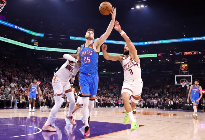 PHOENIX, ARIZONA - FEBRUARY 11: Isaiah Hartenstein #55 of the Oklahoma City Thunder catches a pass under pressure from Dillon Brooks #3 of the Phoenix Suns during the first half at Mortgage Matchup Center on February 11, 2026 in Phoenix, Arizona. NOTE TO USER: User expressly acknowledges and agrees that, by downloading and or using this photograph, User is consenting to the terms and conditions of the Getty Images License Agreement. (Photo by Chris Coduto/Getty Images)
