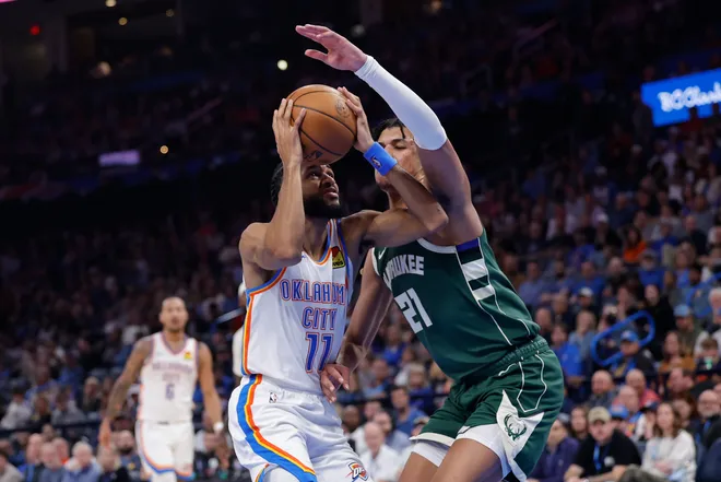 Feb 12, 2026; Oklahoma City, Oklahoma, USA; Oklahoma City Thunder guard Isaiah Joe (11) goes up for a shot as Milwaukee Bucks forward Ousmane Dieng (21) defends during the second half at Paycom Center. Mandatory Credit: Alonzo Adams-Imagn Images