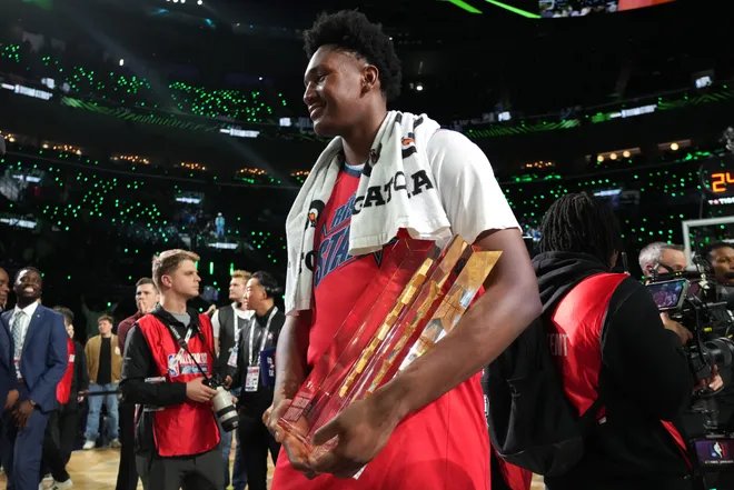 Feb 13, 2026; Inglewood, California, USA; Team Vince frontcourt Derik Queen (22) of the New Orleans Pelicans celebrates with the trophy after defeating Team Melo in an NBA All Star Rising Stars championship game at Intuit Dome. Mandatory Credit: Kirby Lee-Imagn Images