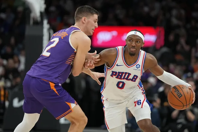 Feb 7, 2026; Phoenix, Arizona, USA; Philadelphia 76ers guard Tyrese Maxey (0) drives on Phoenix Suns guard Collin Gillespie (12) during the second half of an NBA game at Mortgage Matchup Center.