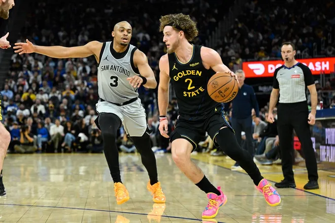 Feb 11, 2026; San Francisco, California, USA; Golden State Warriors guard Brandin Podziemski (2) dribbles against San Antonio Spurs forward Keldon Johnson (3) in the fourth quarter at Chase Center.