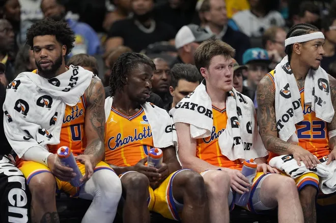 Nov 15, 2025; Charlotte, North Carolina, USA; Charlotte Hornets forward Miles Bridges (0), guard Sion James (4), guard Kon Knueppel (7) and guard Tre Mann (23) at the end of the game on the bench showing fatigue during the second half against the Oklahoma City Thunder at Spectrum Center.