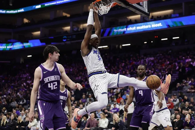 Feb 19, 2026; Sacramento, California, USA; Orlando Magic forward/guard Desmond Bane (3) dunks the ball between Sacramento Kings center Maxime Raynaud (42) and forward Precious Achiuwa (9) during the second quarter at Golden 1 Center.