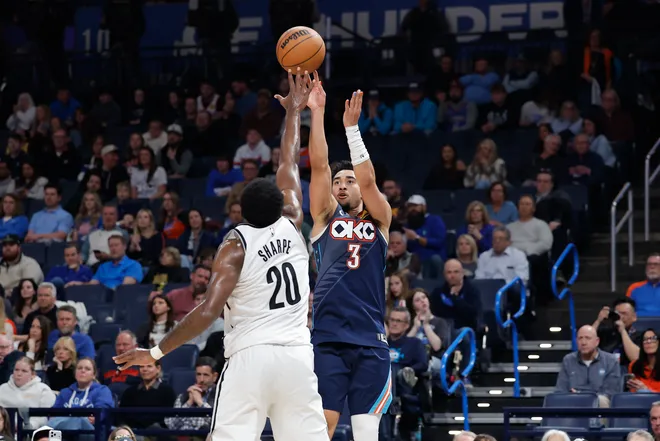 Feb 20, 2026; Oklahoma City, Oklahoma, USA; Oklahoma City Thunder guard Jared McCain (3) shoots a three point basket over Brooklyn Nets center Day'ron Sharpe (20) during the second half at Paycom Center. Mandatory Credit: Alonzo Adams-Imagn Images