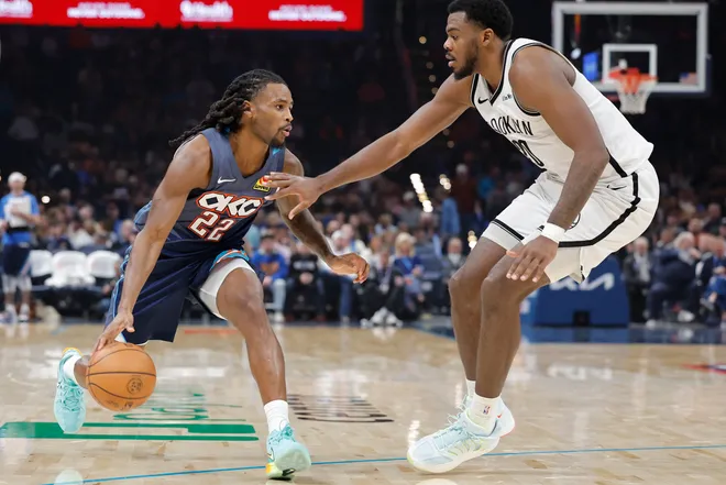Feb 20, 2026; Oklahoma City, Oklahoma, USA; Oklahoma City Thunder guard Cason Wallace (22) drives down the court as Brooklyn Nets center Day'ron Sharpe (20) defends during the second half at Paycom Center. Mandatory Credit: Alonzo Adams-Imagn Images