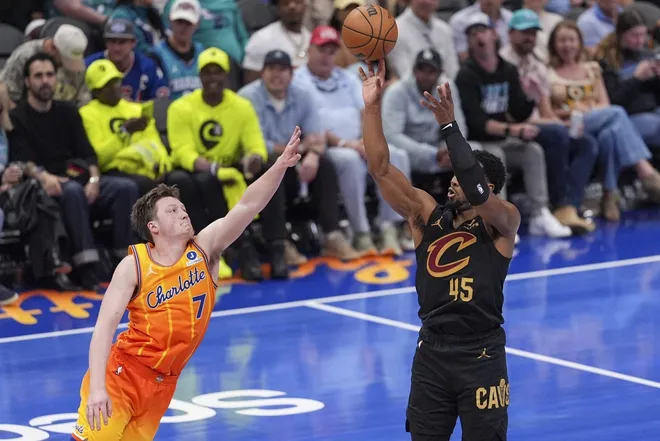 Feb 20, 2026; Charlotte, North Carolina, USA; Cleveland Cavaliers guard Donovan Mitchell (45) shoots against Charlotte Hornets guard Kon Knueppel (7) during the second half at the Spectrum Center.