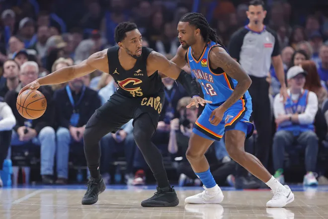 Feb 22, 2026; Oklahoma City, Oklahoma, USA; Cleveland Cavaliers guard Donovan Mitchell (45) drives against Oklahoma City Thunder guard Cason Wallace (22) during the first quarter at Paycom Center. Mandatory Credit: Alonzo Adams-Imagn Images