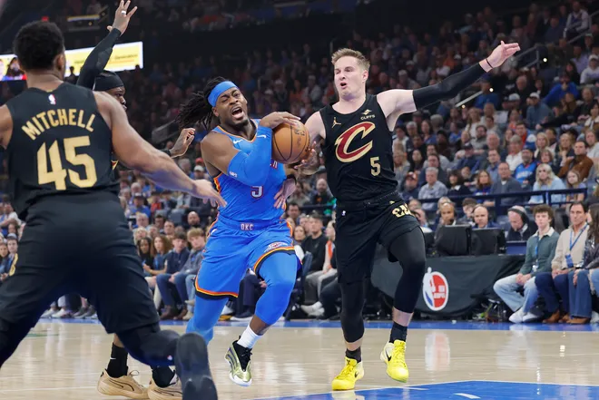 Feb 22, 2026; Oklahoma City, Oklahoma, USA; Oklahoma City Thunder guard Luguentz Dort (5) drives to the basket beside Cleveland Cavaliers guard Sam Merrill (5) during the first half at Paycom Center. Mandatory Credit: Alonzo Adams-Imagn Images