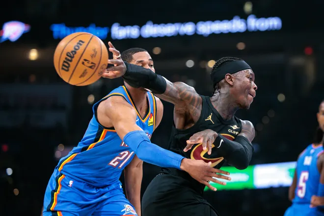 OKLAHOMA CITY, OKLAHOMA - FEBRUARY 22: Dennis Schroder #8 of the Cleveland Cavaliers passes the ball around Aaron Wiggins #21 of the Oklahoma City Thunder during the first half at Paycom Center on February 22, 2026 in Oklahoma City, Oklahoma. NOTE TO USER: User expressly acknowledges and agrees that, by downloading and or using this photograph, User is consenting to the terms and conditions of the Getty Images License Agreement. (Photo by William Purnell/Getty Images)