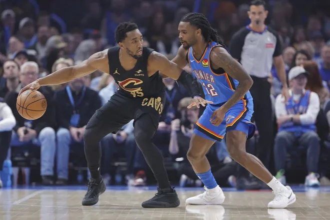 Feb 22, 2026; Oklahoma City, Oklahoma, USA; Cleveland Cavaliers guard Donovan Mitchell (45) drives against Oklahoma City Thunder guard Cason Wallace (22) during the first quarter at Paycom Center.