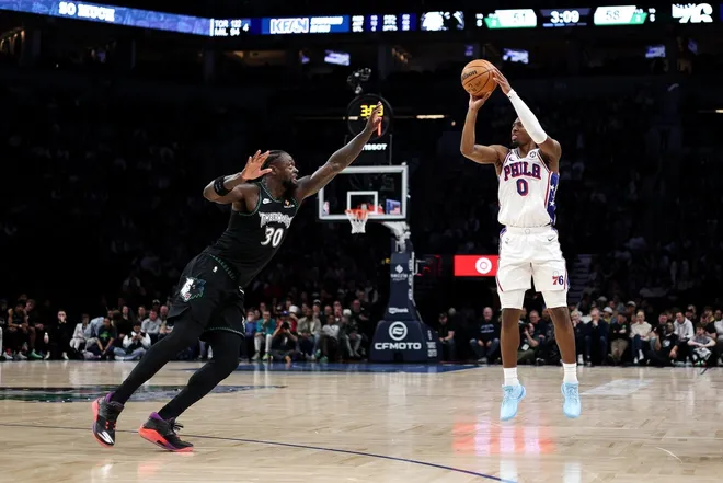 Feb 22, 2026; Minneapolis, Minnesota, USA; Philadelphia 76ers guard Tyrese Maxey (0) shoots over Minnesota Timberwolves forward Julius Randle (30) during the first half at Target Center.