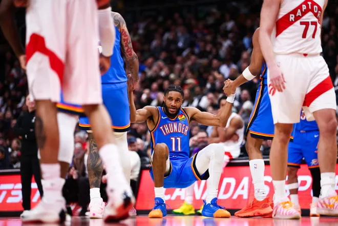 TORONTO, CANADA - FEBRUARY 24: Isaiah Joe #11 of the Oklahoma City Thunder is helped up by teammates during the second half of their NBA game against the Toronto Raptors at Scotiabank Arena on February 24, 2026 in Toronto, Ontario, Canada. NOTE TO USER: User expressly acknowledges and agrees that, by downloading and or using this photograph, User is consenting to the terms and conditions of the Getty Images License Agreement. (Photo by Cole Burston/Getty Images)