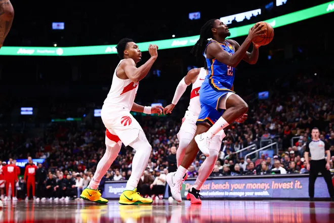 TORONTO, CANADA - FEBRUARY 24: Cason Wallace #22 of the Oklahoma City Thunder drives to the net against Scottie Barnes #4 of the Toronto Raptors during the second half of their NBA game at Scotiabank Arena on February 24, 2026 in Toronto, Ontario, Canada. NOTE TO USER: User expressly acknowledges and agrees that, by downloading and or using this photograph, User is consenting to the terms and conditions of the Getty Images License Agreement. (Photo by Cole Burston/Getty Images)