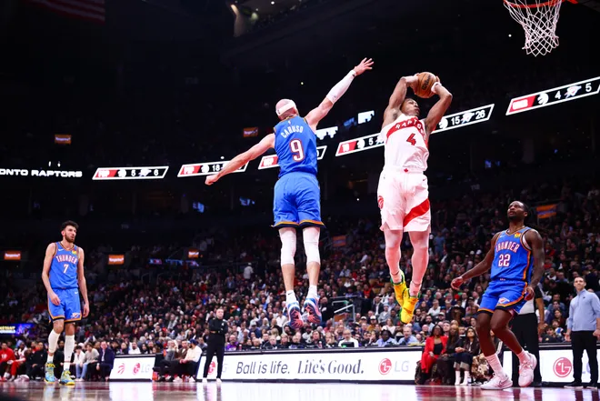 TORONTO, CANADA - FEBRUARY 24: Scottie Barnes #4 of the Toronto Raptors drives to the net against Alex Caruso #9 of the Oklahoma City Thunder during the first half of their NBA game at Scotiabank Arena on February 24, 2026 in Toronto, Ontario, Canada. NOTE TO USER: User expressly acknowledges and agrees that, by downloading and or using this photograph, User is consenting to the terms and conditions of the Getty Images License Agreement. (Photo by Cole Burston/Getty Images)