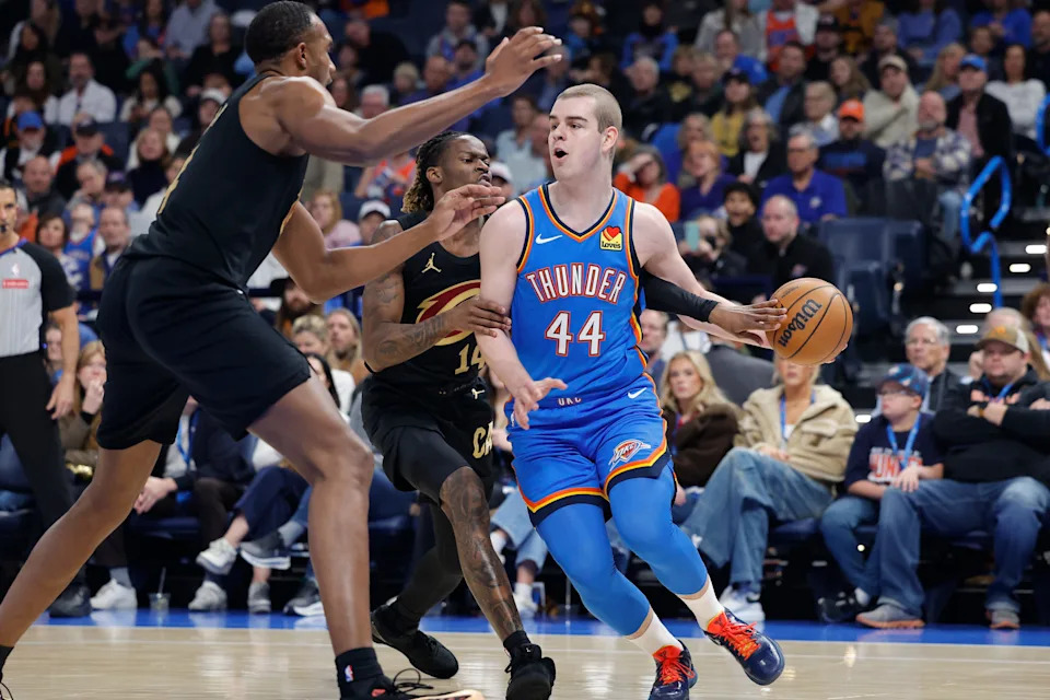 Feb 22, 2026; Oklahoma City, Oklahoma, USA; Oklahoma City Thunder guard Nikola Topić (44) drives past Cleveland Cavaliers guard Keon Ellis (14) during the first half at Paycom Center. Mandatory Credit: Alonzo Adams-Imagn Images