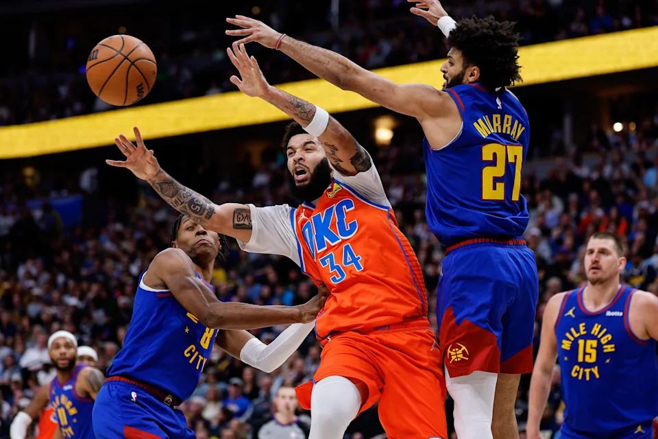 Feb 1, 2026; Denver, Colorado, USA; Oklahoma City Thunder guard Kenrich Williams (34) passes the ball as Denver Nuggets guard Jamal Murray (27) and guard Peyton Watson (8) defend in the second quarter at Ball Arena. Mandatory Credit: Isaiah J. Downing-Imagn Images