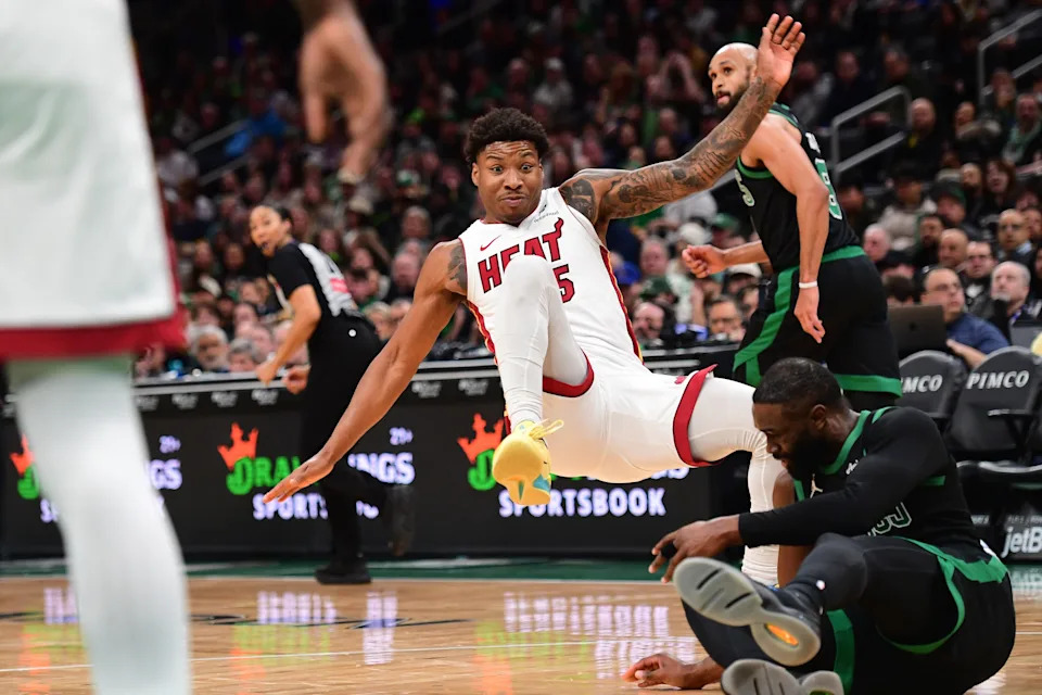 Feb 6, 2026; Boston, Massachusetts, USA; Miami Heat guard Davion Mitchell (45) falls over Boston Celtics guard Jaylen Brown (7) during the second half at TD Garden. Mandatory Credit: Bob DeChiara-Imagn Images