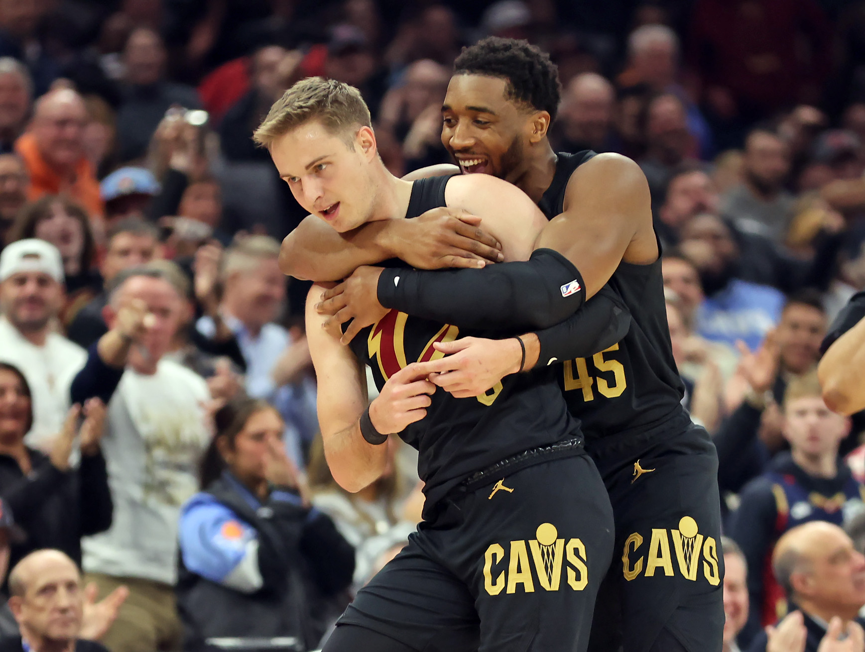 Cleveland Cavaliers guard Donovan Mitchell jumps on the back of Cleveland Cavaliers guard Sam Merrill after Merrill sank a three against the Washington Wizards in the first half of play. 