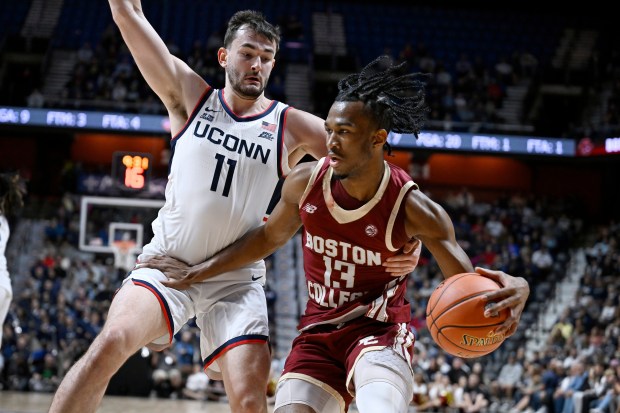 Boston College guard Donald Hand Jr. (13) is guarded by UConn forward Alex Karaban (11) during the first half of an exhibition NCAA college basketball game, Monday, Oct. 13, 2025, in Uncasville, Conn. (AP Photo/Jessica Hill)