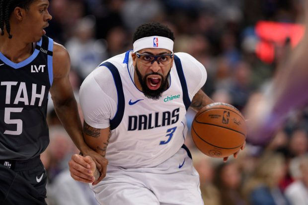Mavericks forward Anthony Davis (3) drives to the basket while guarded by Jazz forward Cody Williams (5) during the first half of a game, Thursday, Jan. 8, 2026, in Salt Lake City. (AP Photo/Tyler Tate)