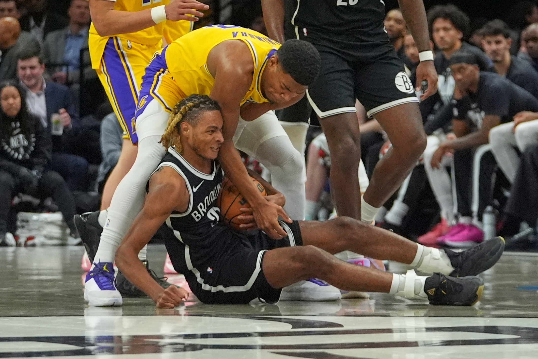 Lakers forward Rui Hachimura, above, battles for control of the...