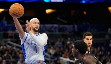 Orlando Magic guard Jalen Suggs (4) passes the ball over Brooklyn Nets guard Drake Powell, right, during the second half of an NBA basketball game, Thursday, Feb. 5, 2026, in Orlando, Fla. (AP Photo/John Raoux)