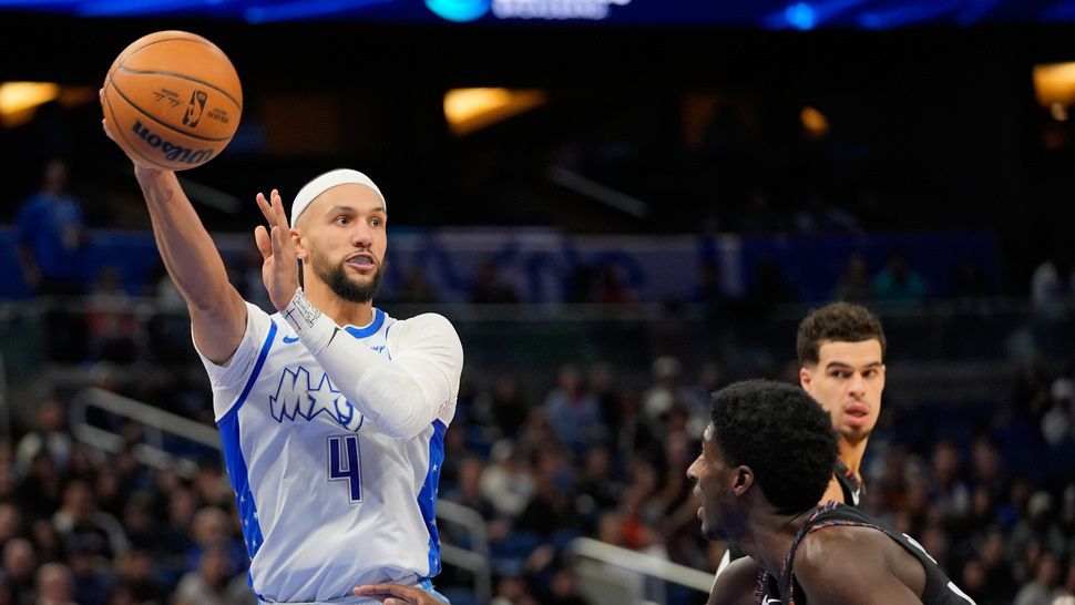 Orlando Magic guard Jalen Suggs (4) passes the ball over Brooklyn Nets guard Drake Powell, right, during the second half of an NBA basketball game, Thursday, Feb. 5, 2026, in Orlando, Fla. (AP Photo/John Raoux)