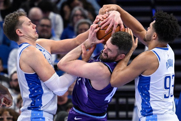 Utah Jazz forward Kevin Love, center, battles for a rebound against Orlando Magic forwards Moritz Wagner, left, and Noah Penda (93) during the second half of an NBA game on Saturday, Feb. 7, 2026, in Orlando, Fla. (AP Photo/Phelan M. Ebenhack)