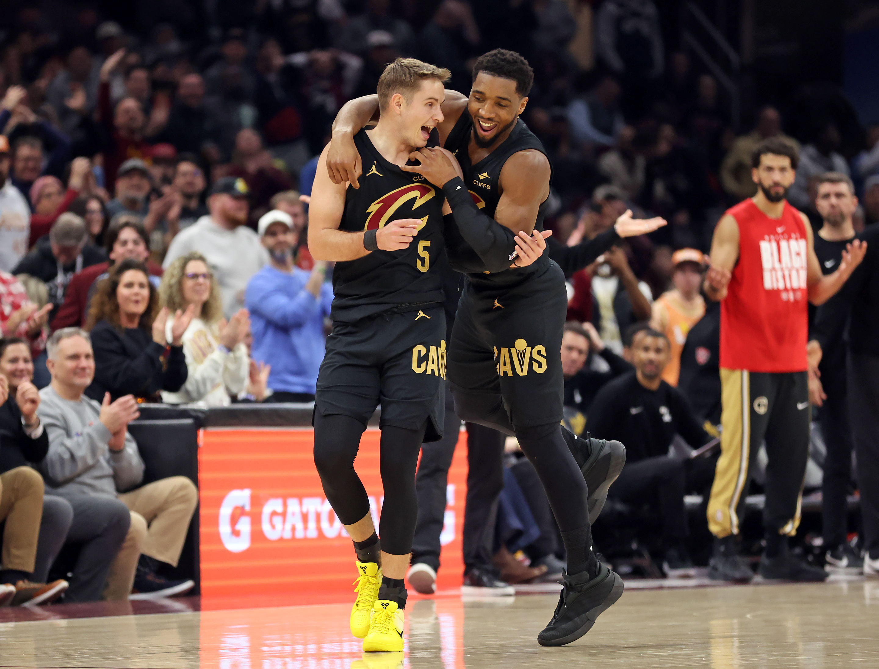 Cleveland Cavaliers guard Donovan Mitchell jumps on the back of Cleveland Cavaliers guard Sam Merrill after Merrill sank a three against the Washington Wizards in the first half of play. 