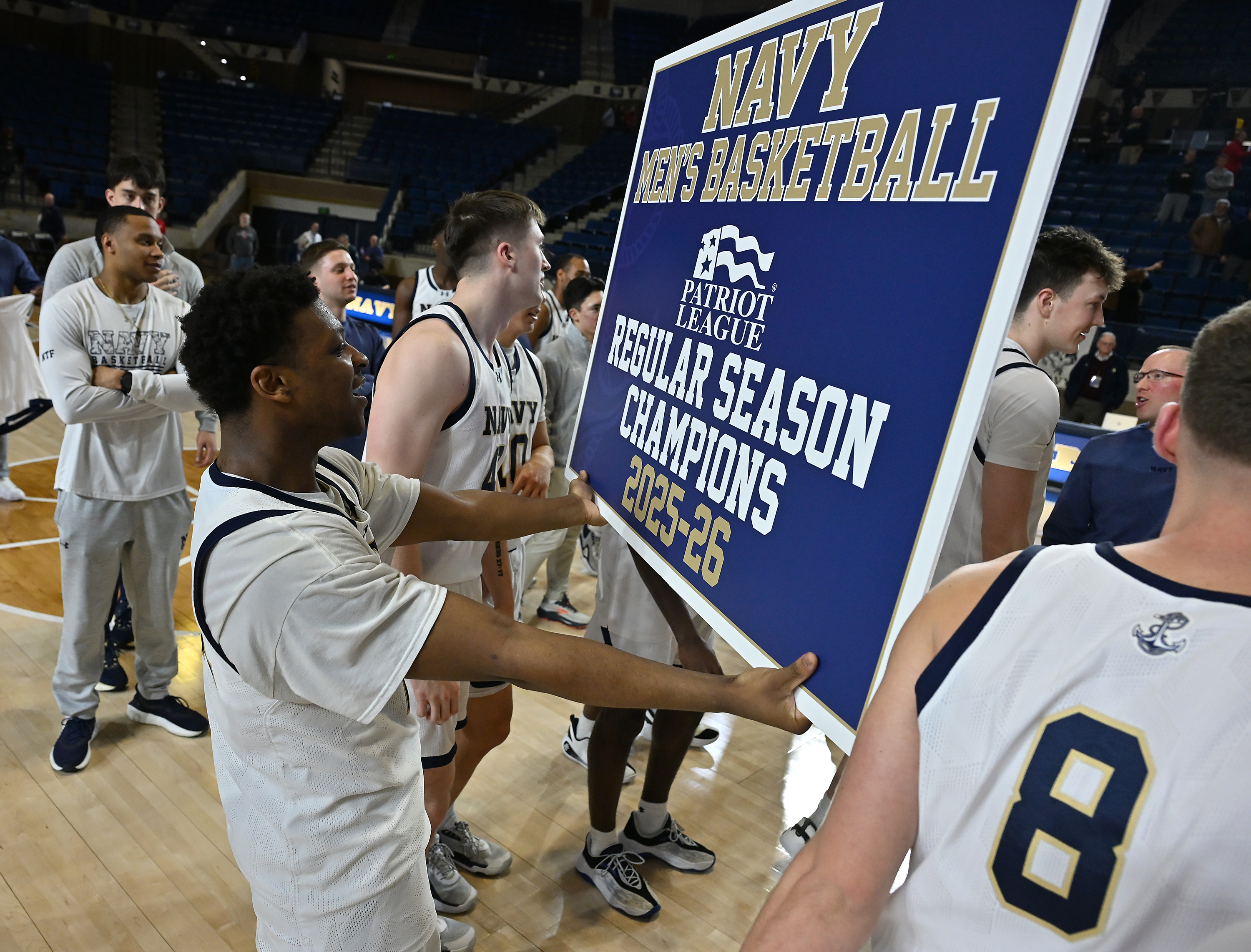 Navy Midshipmen guard Jordan Pennick #21 holds a Regular Season Champions sign after the game. The Navy Midshipmen defeated the Lehigh Mountain Hawks, 72-49, to become the Patriot League Regular Season Champions in men's NCAA basketball. (Paul W. Gillespie/Staff)