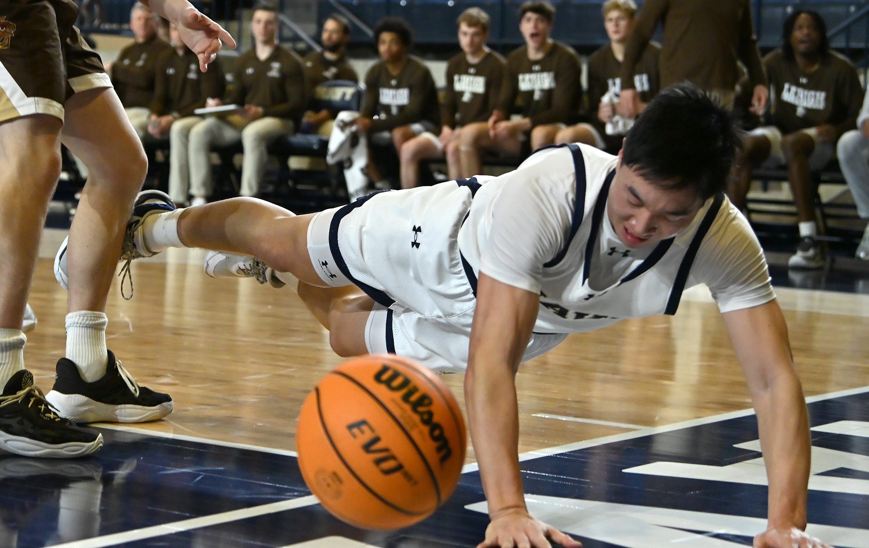 Navy Midshipmen guard Jinwoo Kim #10 dives for the ball trying to keep it in bounds during the first half. The Navy Midshipmen host the Lehigh Mountain Hawks in men's NCAA basketball. (Paul W. Gillespie/Staff)