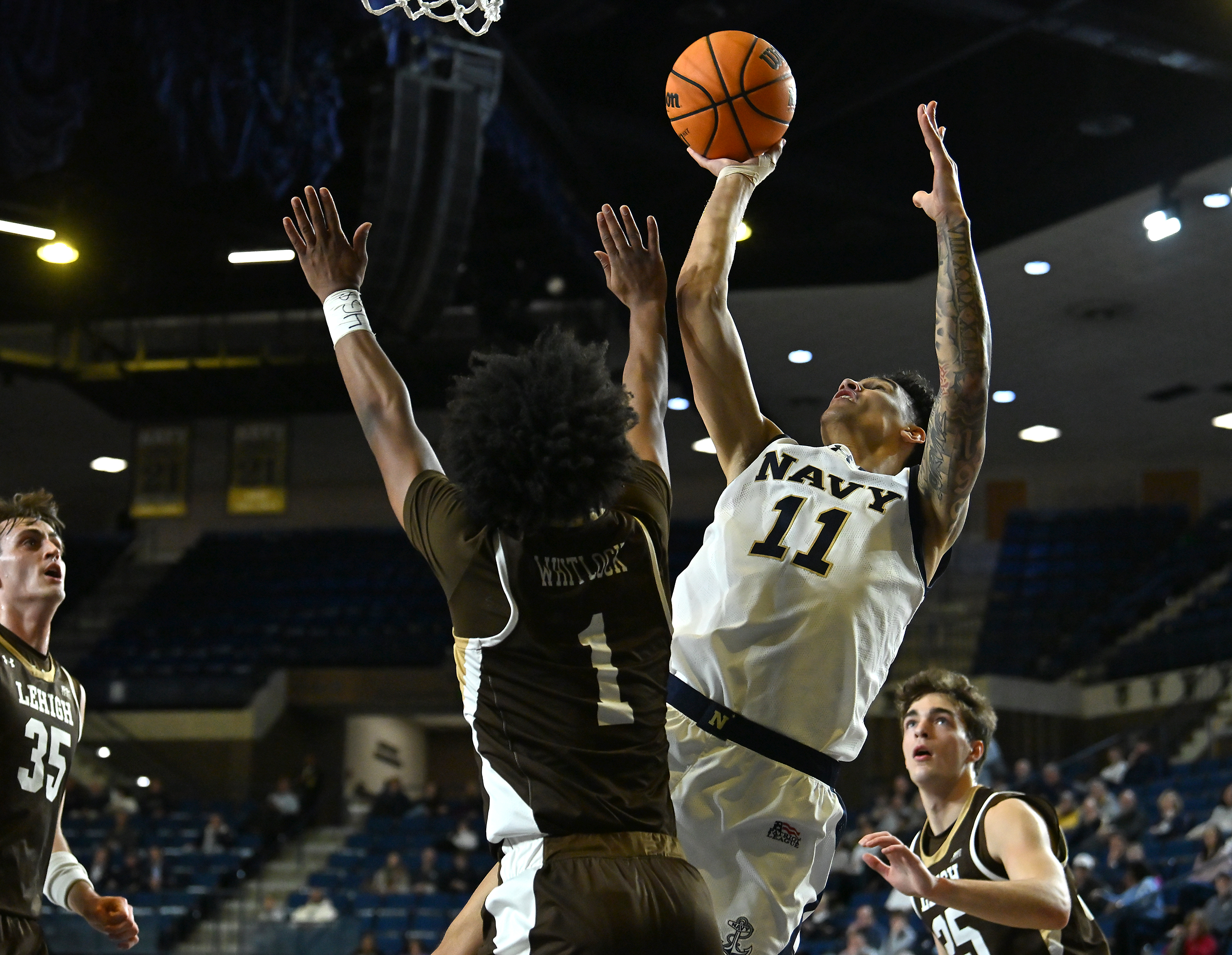 Navy Midshipmen forward Donovan Draper #11 shoots over Lehigh Mountain Hawks guard Nasir Whitlock #1 during the first half. The Navy Midshipmen host the Lehigh Mountain Hawks in men's NCAA basketball. (Paul W. Gillespie/Staff)