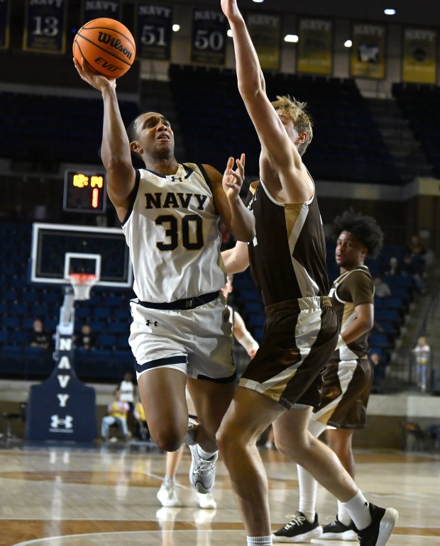 Navy Midshipmen forward Mike Woods #30 is good for two shooting over Lehigh Mountain Hawks center Tommy Conniff #44 during the first half. The Navy Midshipmen host the Lehigh Mountain Hawks in men's NCAA basketball. (Paul W. Gillespie/Staff)