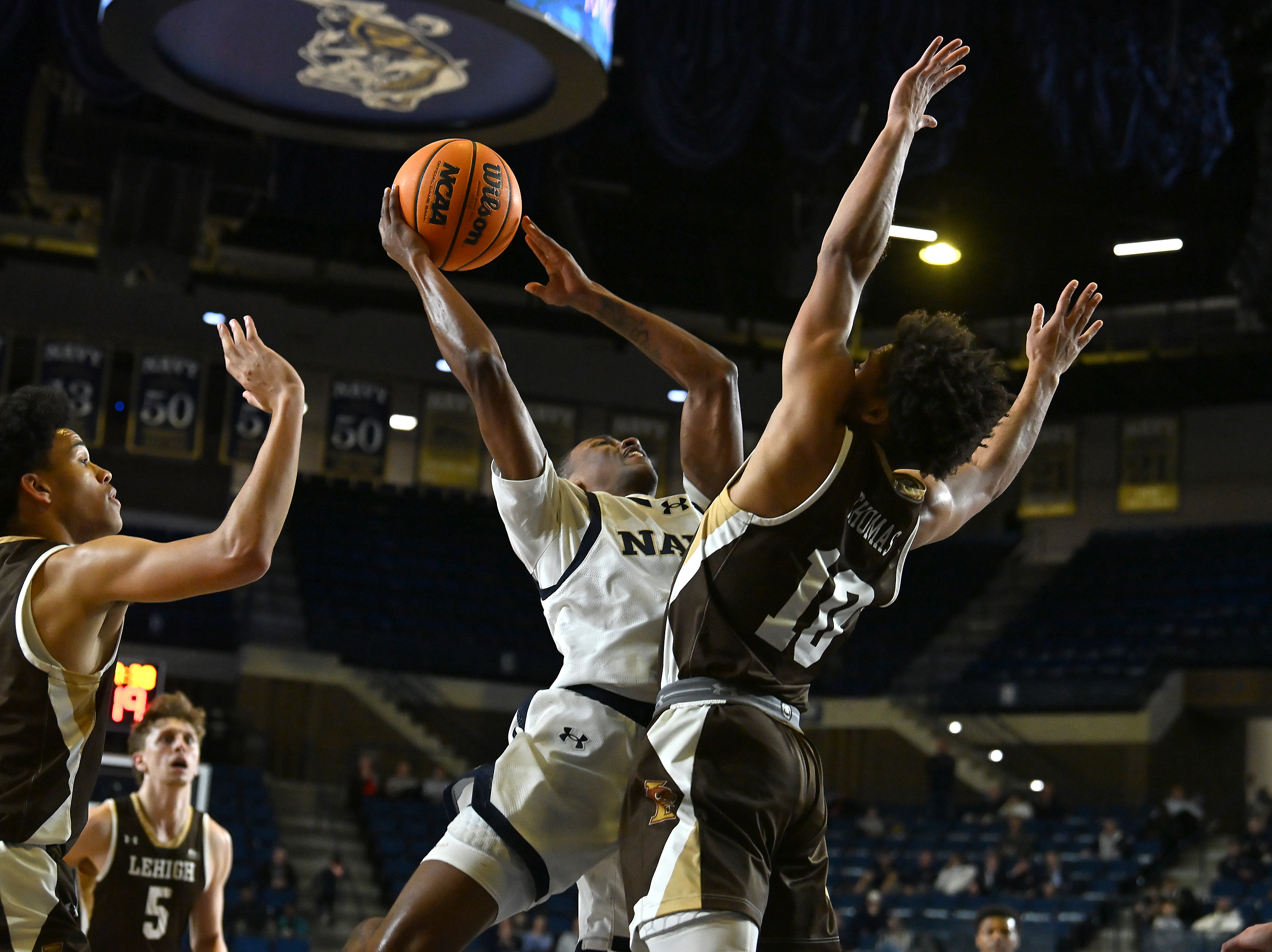 Navy Midshipmen guard Cam Cole #2 makes a basket and draws a foul by Lehigh Mountain Hawks guard Caleb Thomas #10 during the first half. The Navy Midshipmen host the Lehigh Mountain Hawks in men's NCAA basketball. (Paul W. Gillespie/Staff)