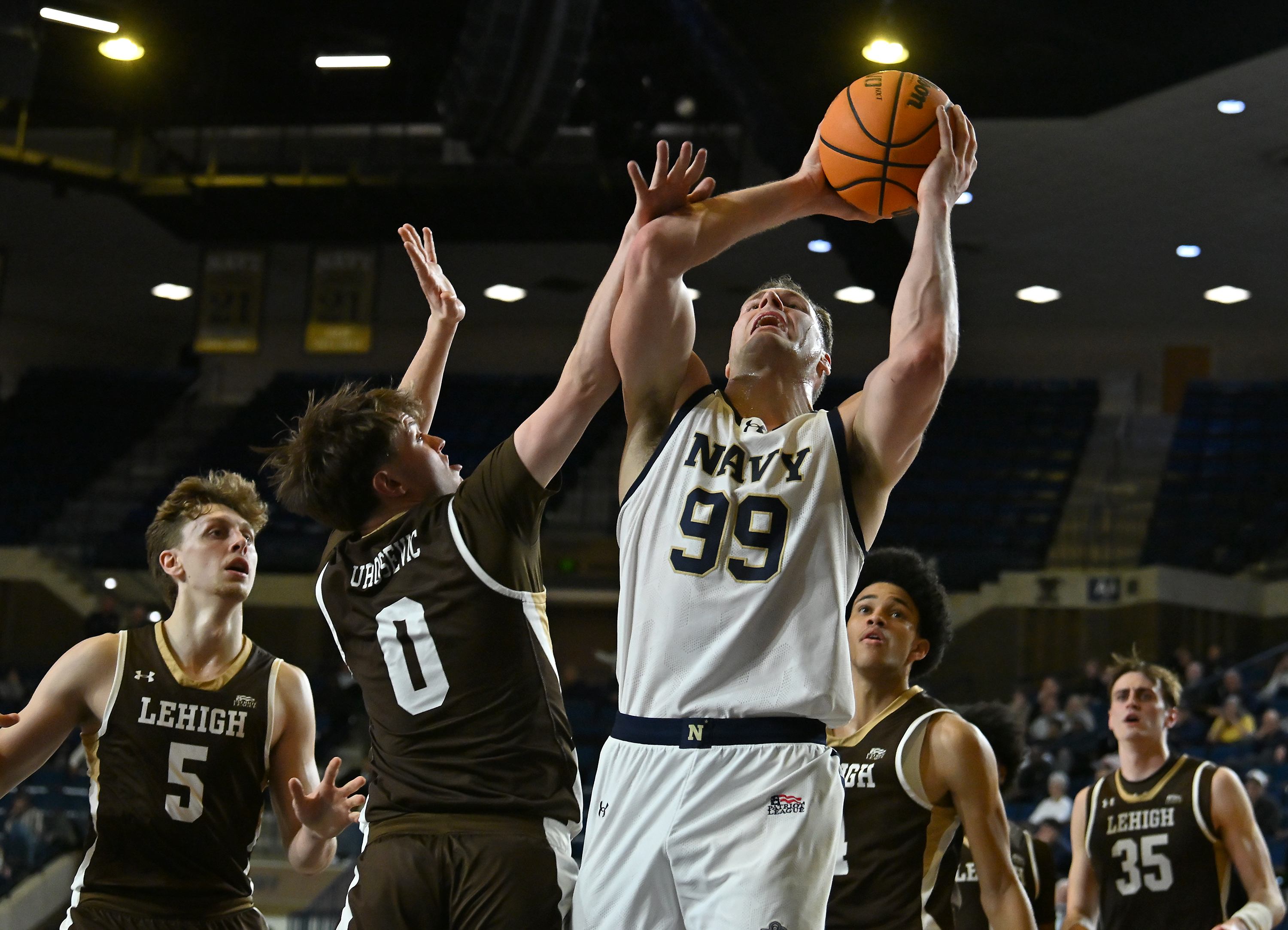 Navy Midshipmen center Aidan Kehoe #99 is fouled by Lehigh Mountain Hawks guard Caesar Burrows #2, and makes one of two foul shots during the first half. The Navy Midshipmen host the Lehigh Mountain Hawks in men's NCAA basketball. (Paul W. Gillespie/Staff)
