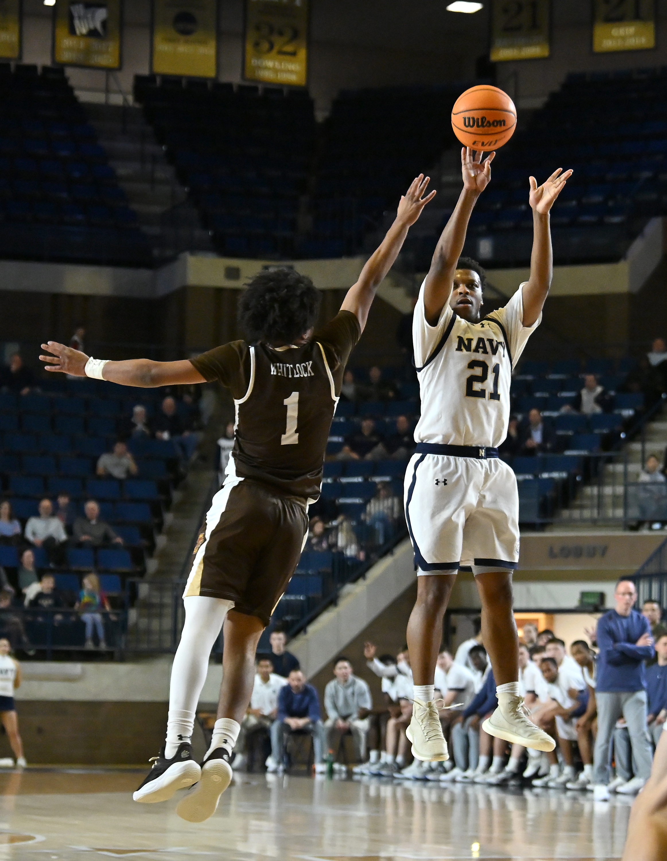 Navy Midshipmen guard Jordan Pennick #21 goes for a three point shot over Lehigh Mountain Hawks guard Nasir Whitlock #1 during the first half. The Navy Midshipmen host the Lehigh Mountain Hawks in men's NCAA basketball. (Paul W. Gillespie/Staff)
