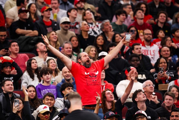 A fan cheers to get on the big screen in the third quarter during a game between the Bulls and 76ers on Dec. 26, 2025, at the United Center. (Dominic Di Palermo/Chicago Tribune)