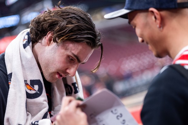 Chicago Bulls guard Josh Giddey signs a jersey for Ryota Iida (cq), of Japan, ahead of a game against the Portland Trail Blazers at the United Center in Chicago on Feb. 26, 2026. (Josh Boland/Chicago Tribune)