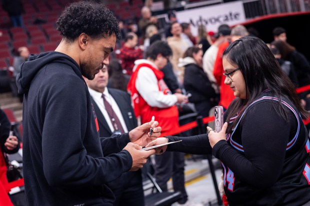 Chicago Bulls guard Tre Jones signs an autograph for a fan ahead of a game against the Portland Trail Blazers at the United Center in Chicago on Feb. 26, 2026. (Josh Boland/Chicago Tribune)