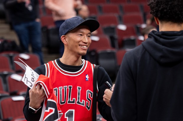 Ryota Iida (cq), of Japan, smiles as he Chicago Bulls guard Tre Jones hands a marker to him after signing his jersey ahead of a game against the Portland Trail Blazers at the United Center in Chicago on Feb. 26, 2026. (Josh Boland/Chicago Tribune)