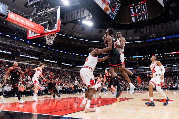 Toronto Raptors guard Immanuel Quickley (5) shoots a layup over Chicago Bulls guard Rob Dillingham (4) and Chicago Bulls forward Jalen Smith (25) in the first half of a game against the Toronto Raptors at the United Center in Chicago on Feb. 19, 2026. (Josh Boland/Chicago Tribune)