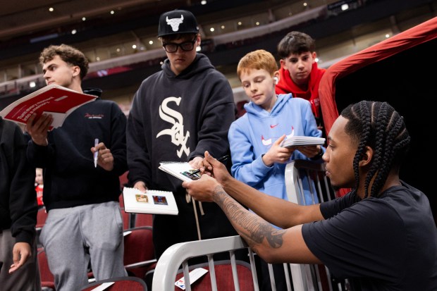 Chicago Bulls guard Rob Dillingham signs autographs for fans ahead of a game against the Toronto Raptors at the United Center in Chicago on Feb. 19, 2026. (Josh Boland/Chicago Tribune)