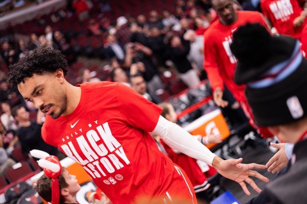 Chicago Bulls guard Tre Jones high fives young fans as he runs onto the court ahead of a against the Toronto Raptors at the United Center in Chicago on Feb. 19, 2026. (Josh Boland/Chicago Tribune)