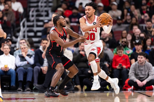 Chicago Bulls guard Tre Jones (30) carries the ball against Toronto Raptors guard Immanuel Quickley (5) in the first half of a game against the Toronto Raptors at the United Center in Chicago on Feb. 19, 2026. (Josh Boland/Chicago Tribune)