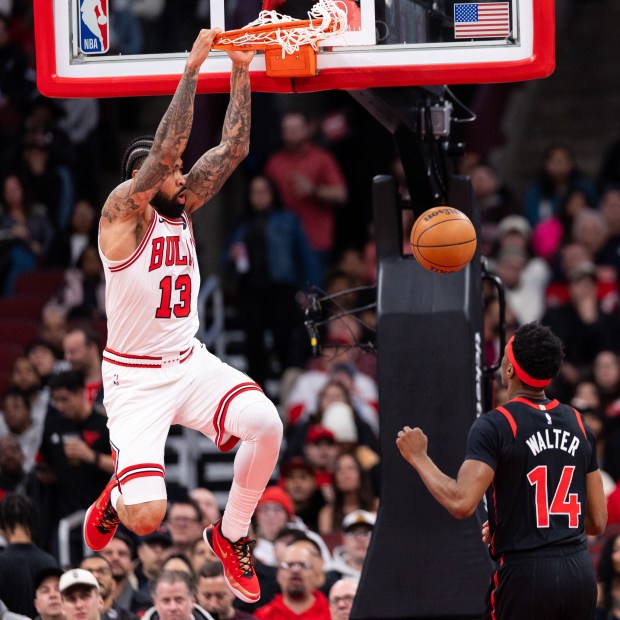 Chicago Bulls center Nick Richards (13) dunks over Toronto Raptors guard Ja'kobe Walter (14) in the first half of a game against the Toronto Raptors at the United Center in Chicago on Feb. 19, 2026. (Josh Boland/Chicago Tribune)